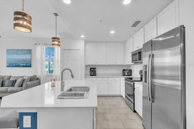 kitchen with a center island with sink, white cabinetry, sink, pendant lighting, and stainless steel appliances