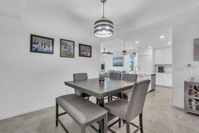 dining room featuring crown molding, sink, ceiling fan with notable chandelier, and light tile patterned floors