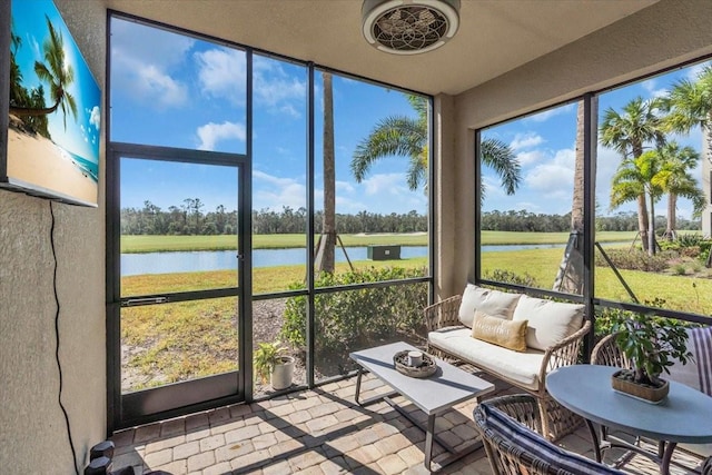 sunroom featuring a water view