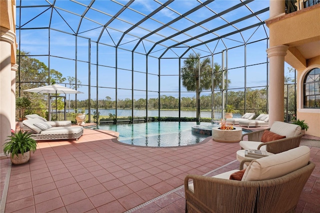 pool featuring an outdoor living space with a fire pit, glass enclosure, a patio, and a water view