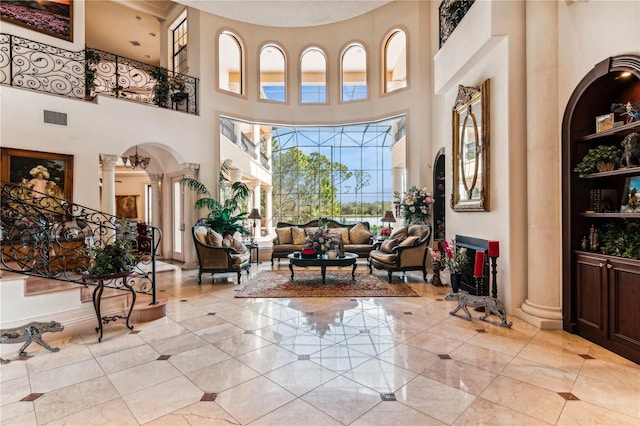 entryway with light tile patterned floors, decorative columns, visible vents, arched walkways, and stairway