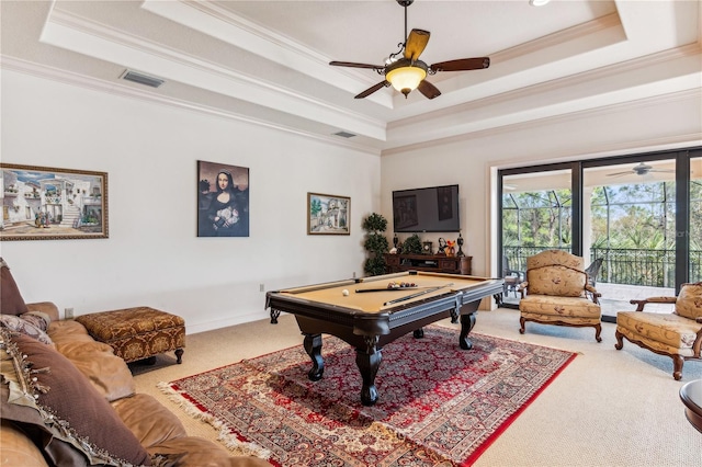 rec room with a tray ceiling, visible vents, crown molding, and carpet flooring