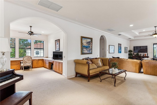 living area with crown molding, a ceiling fan, visible vents, and light colored carpet