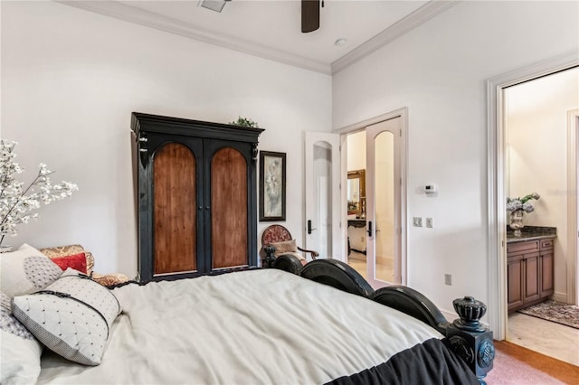 bedroom featuring ensuite bath, ornamental molding, ceiling fan, and light colored carpet