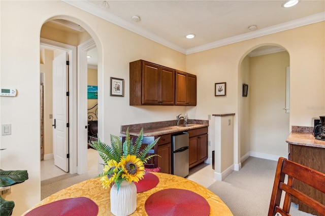 kitchen with arched walkways, light colored carpet, crown molding, and fridge