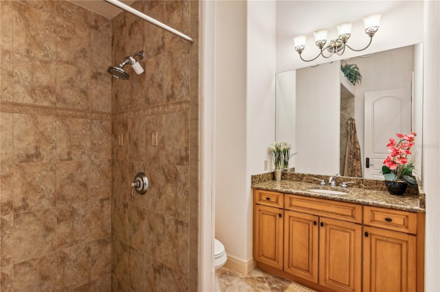 full bath featuring tiled shower, vanity, and toilet