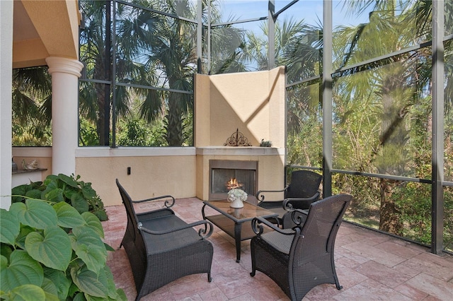 sunroom featuring a lit fireplace and a wealth of natural light