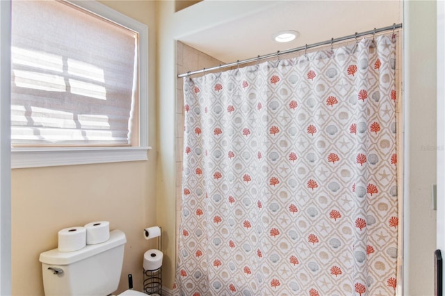 bathroom featuring curtained shower and toilet