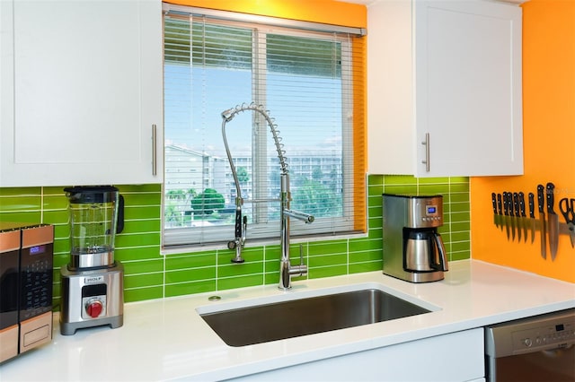 kitchen with white cabinetry, backsplash, and sink