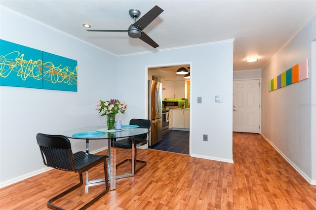 dining area with hardwood / wood-style floors, crown molding, and ceiling fan