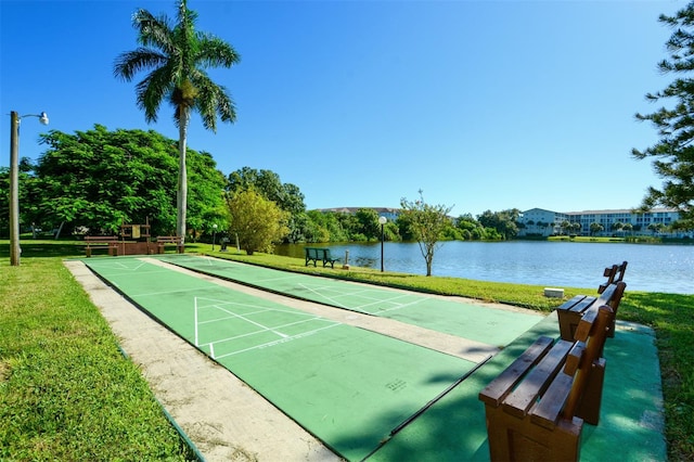 view of home's community with a water view and a yard