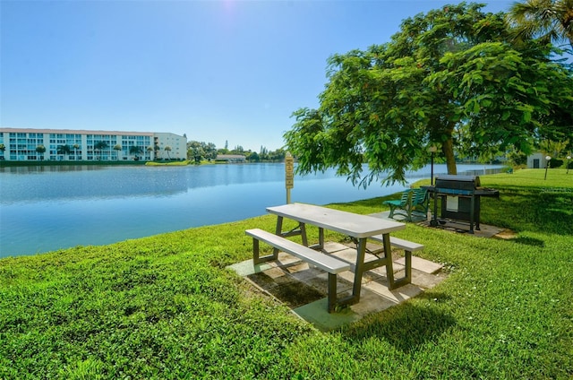 view of home's community with a water view and a lawn