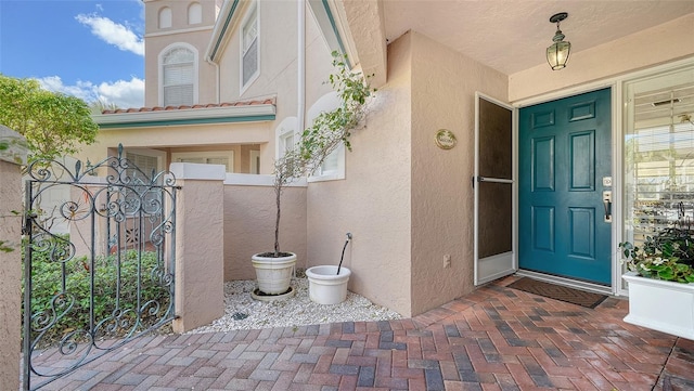 entrance to property with a gate and stucco siding