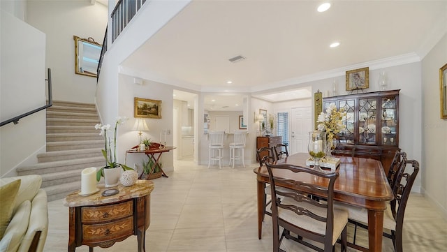 dining space with crown molding, stairs, visible vents, and baseboards
