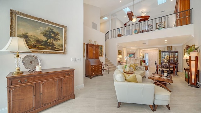 living room featuring stairs, light tile patterned floors, baseboards, high vaulted ceiling, and a ceiling fan