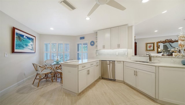 kitchen featuring sink, kitchen peninsula, white cabinetry, ceiling fan, and stainless steel dishwasher