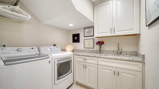 clothes washing area featuring sink, independent washer and dryer, and cabinets