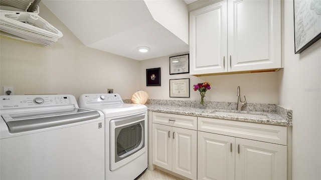 washroom featuring a sink, washing machine and clothes dryer, and cabinet space