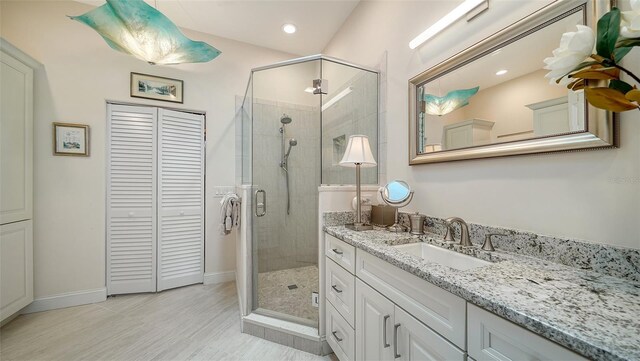 full bathroom featuring a shower stall, a closet, baseboards, recessed lighting, and vanity