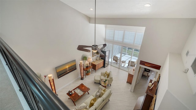 living room with a high ceiling and ceiling fan