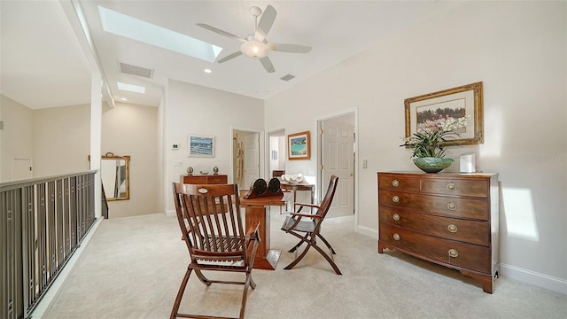 interior space featuring light colored carpet, a skylight, and ceiling fan