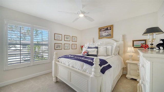 bedroom with light colored carpet, ceiling fan, and baseboards