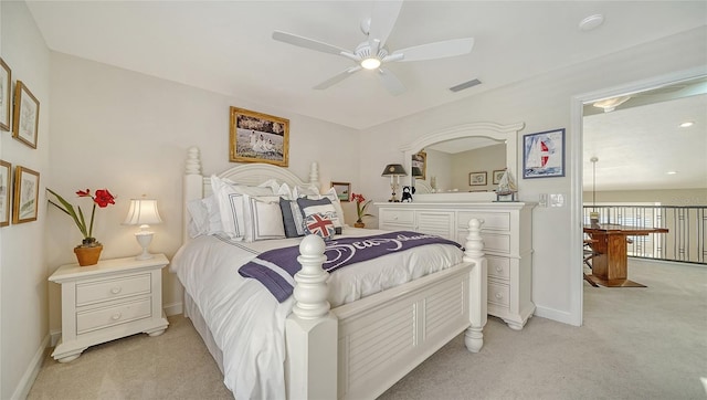 bedroom featuring baseboards, visible vents, a ceiling fan, and light colored carpet