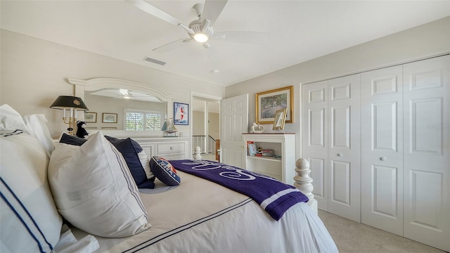 bedroom with visible vents, ceiling fan, a closet, and light colored carpet