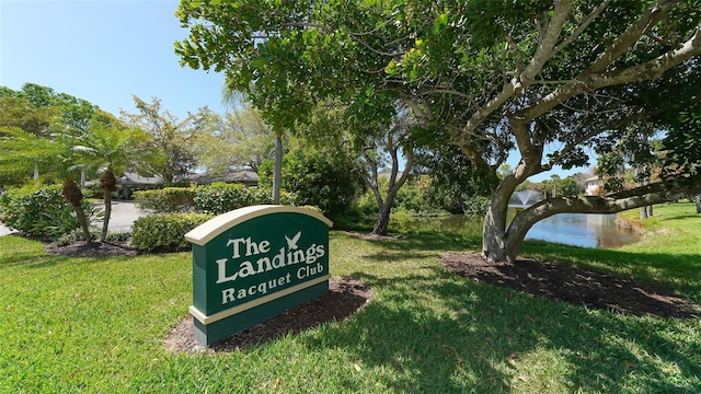 view of property's community with a water view and a lawn