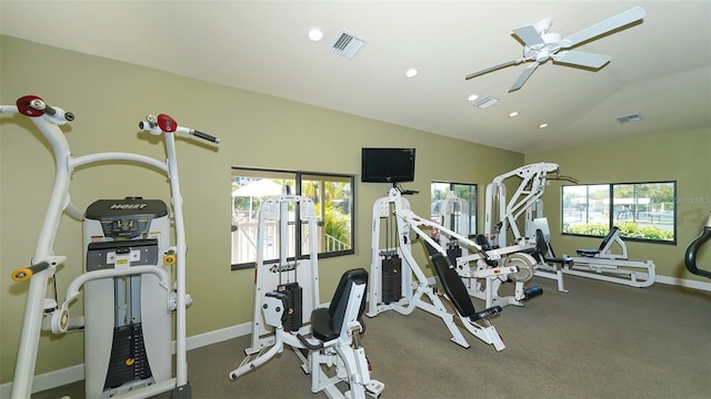 gym with baseboards, visible vents, ceiling fan, and lofted ceiling