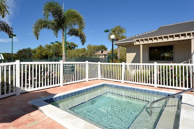 view of pool with fence and a community hot tub
