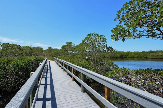 view of dock featuring a water view and a forest view