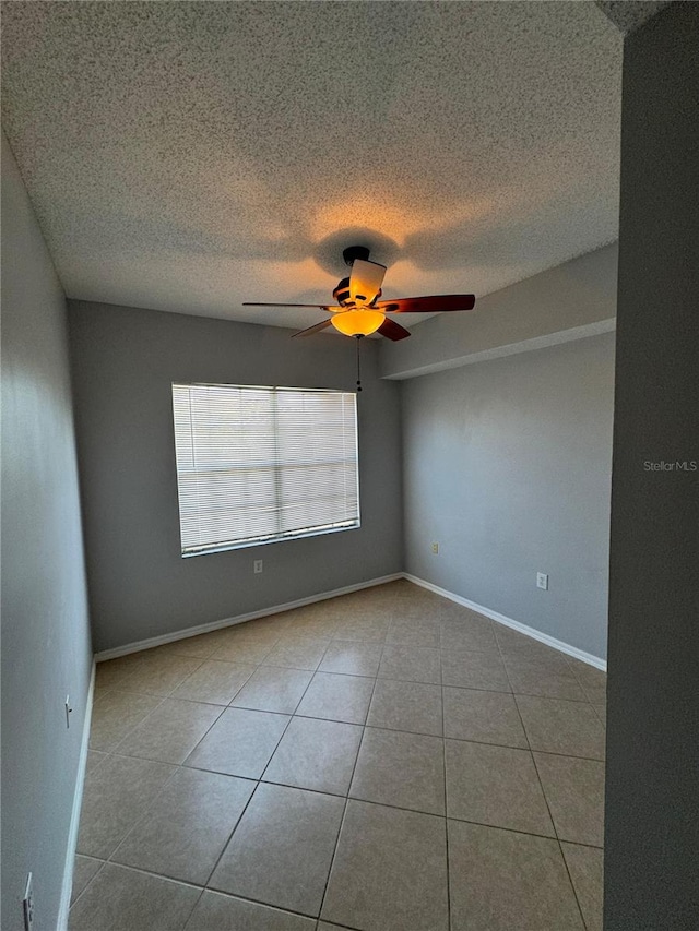 tiled spare room featuring ceiling fan and a textured ceiling