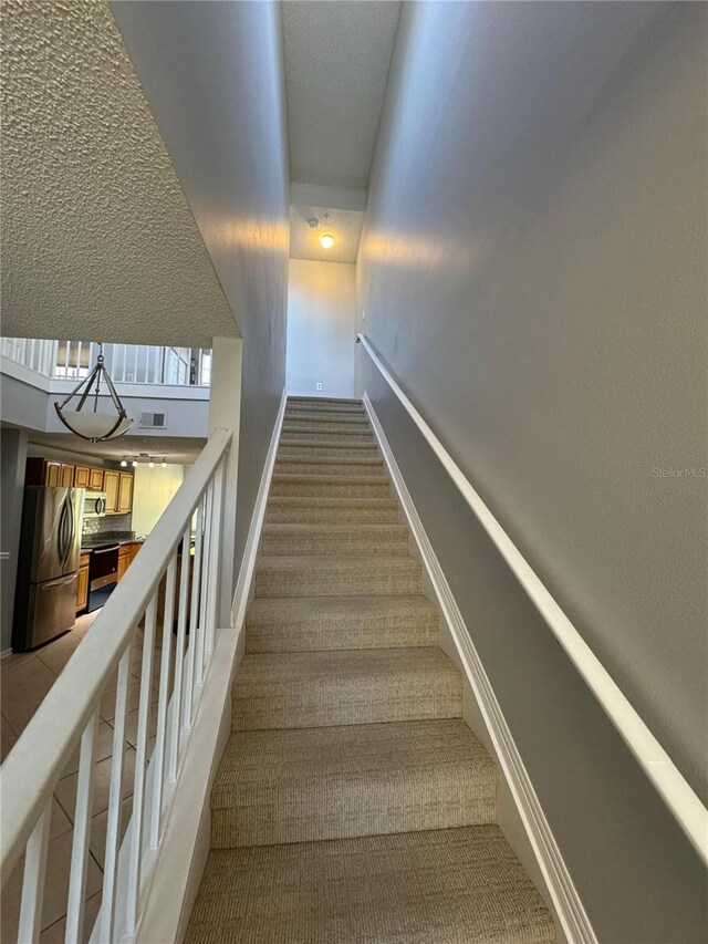 stairway featuring carpet