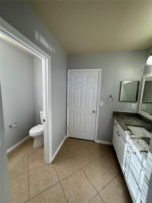 bathroom with vanity, toilet, and tile patterned floors