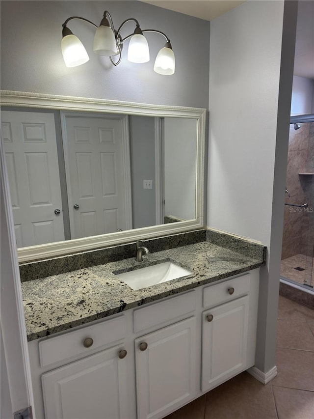 bathroom with a shower with door, tile patterned floors, and vanity