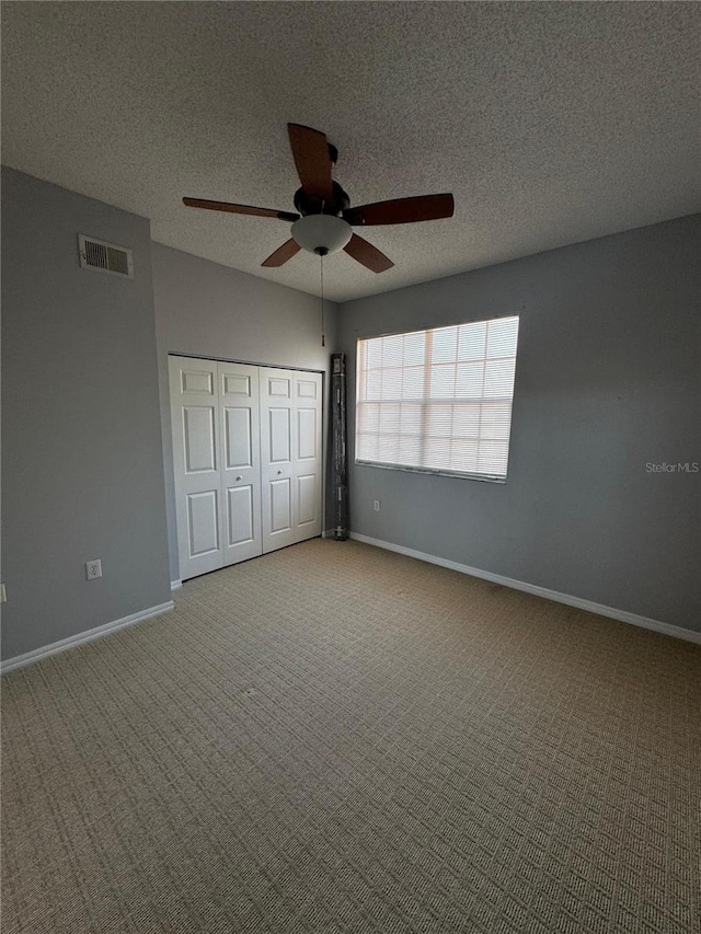 unfurnished bedroom with carpet floors, a textured ceiling, a closet, and ceiling fan