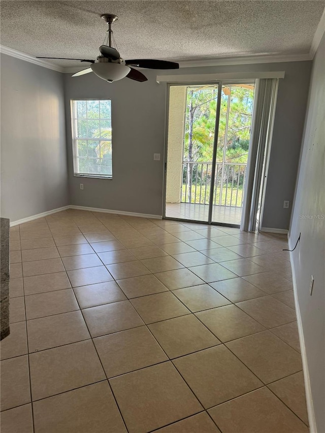 empty room featuring a textured ceiling, light tile patterned floors, and plenty of natural light