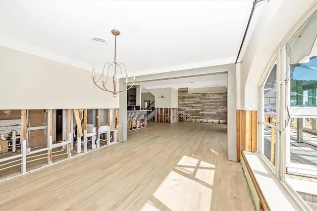 dining space featuring hardwood / wood-style flooring, ornamental molding, wooden walls, and a chandelier