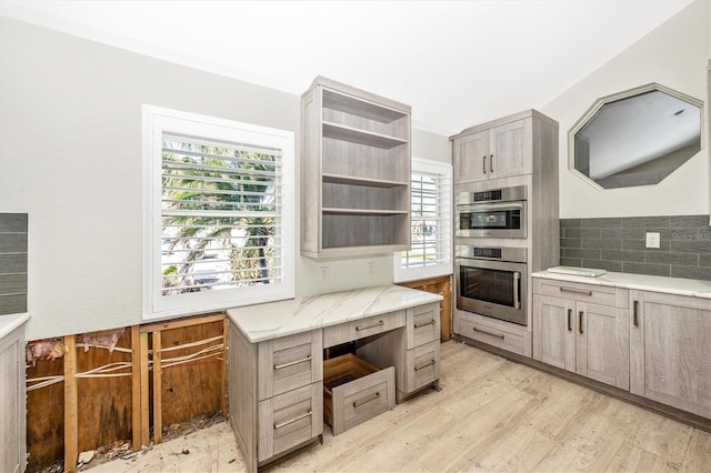 kitchen featuring double oven, decorative backsplash, and light hardwood / wood-style floors