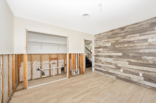 empty room featuring wood-type flooring and wooden walls