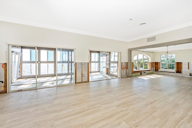 interior space featuring light hardwood / wood-style floors, an inviting chandelier, and crown molding