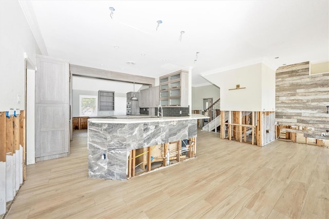 kitchen with wood walls, light hardwood / wood-style flooring, and crown molding