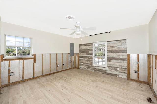 empty room with a wealth of natural light and wood walls