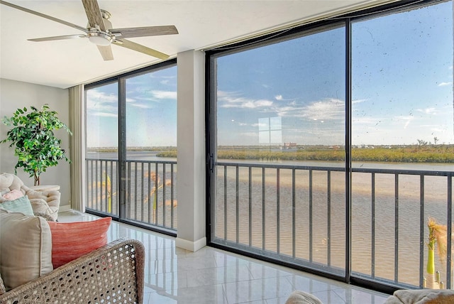 sunroom with a water view and ceiling fan