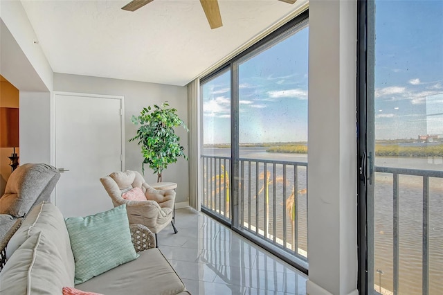 sunroom / solarium with a water view and ceiling fan