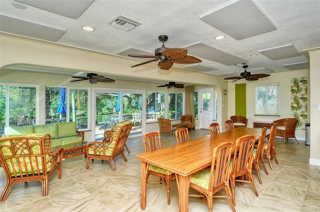 dining room featuring ceiling fan, a textured ceiling, and a wealth of natural light