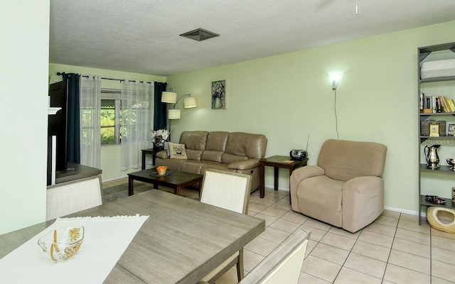 living room featuring a textured ceiling and light tile patterned flooring