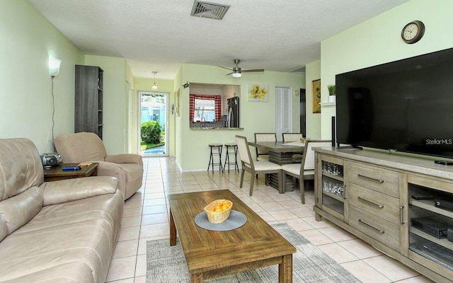 tiled living room featuring ceiling fan and a textured ceiling