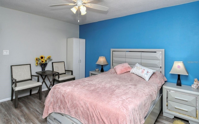 bedroom featuring a textured ceiling, wood-type flooring, and ceiling fan